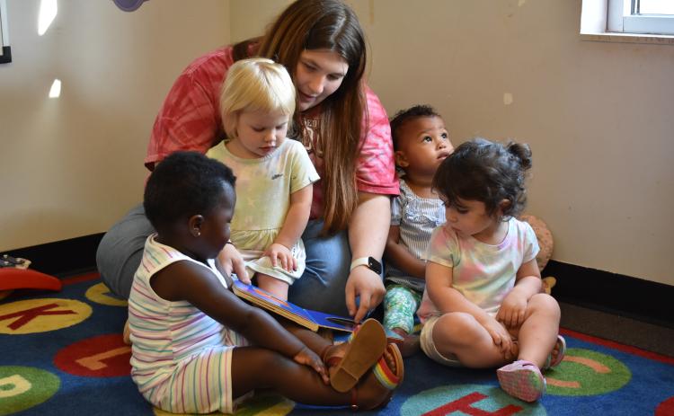 Brandy Epps huddles children in the 1-year-old class for circle time. These times include storytelling, identifying colors and singing songs. (Photo/Sarah Evans)