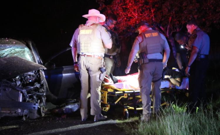 Law enforcement officers surround Taran Allen, who was taken to a local hospital after a high-speed chase ended with him crashing in a Lexington yard. (Photo/Tom Thon)