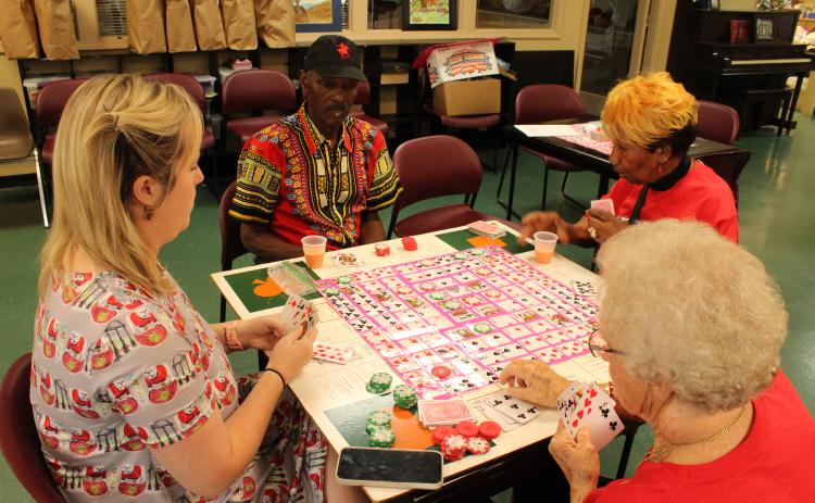 (Andrea Gutierrez/The Oglethorpe Echo) Director Corie Robinson, left, plays a card game with Gary Armstrong, top, Roz Echols, right, and Gwen Kelley, bottom, at the Oglethorpe Senior Center last week. The center provides activities, meals and transportation for the county’s seniors.