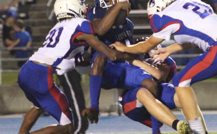 (Donny Faust/For The Oglethorpe Echo) Michael Fleming, Joseph Turner and LT Faust gang up to tackle a Banks County ball carrier. Oglethorpe County scored first, but lost 21-7 on Friday.
