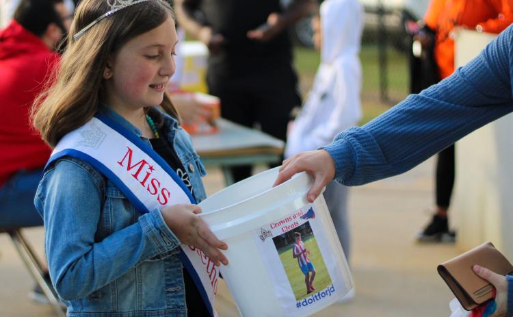 Miss Oglethorpe Princess Lilah Trejo, holds bucket for donations to support Jacob Dake, Oglethorpe County high school, Sept. 29, 2022. Dake was in a motorcycle accident on Sept. 15, and has had extensive surgeries since. (Aisha Shulz/The Oglethorpe Echo)
