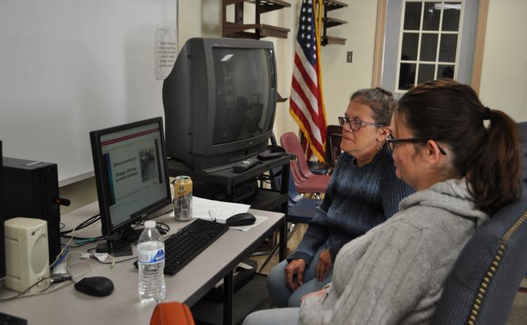 Bus driver trainer Felicia Dellaria (left) and Brandi Hokanson, a new bus driver trainee, watch a driving safety video last week. The trainees spent the morning completing a portion of the 12 hours of required class time for a CDL license. (Photo/Megan Fitzgerald)