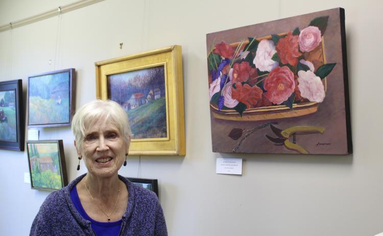 Artist Dortha Jacobson stands beside several of her oil paintings. Jacobson is the first artist to have a gallery at the Winterville Library. (Photo/Lily Baldwin)
