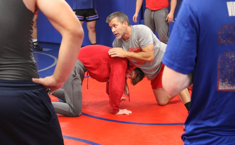 Coach Tim Stoudenmire demonstrates a move with Tanner Mask as the Oglethorpe County wrestling team prepares to open this season later this month. (De Turner/The Oglethorpe Echo)