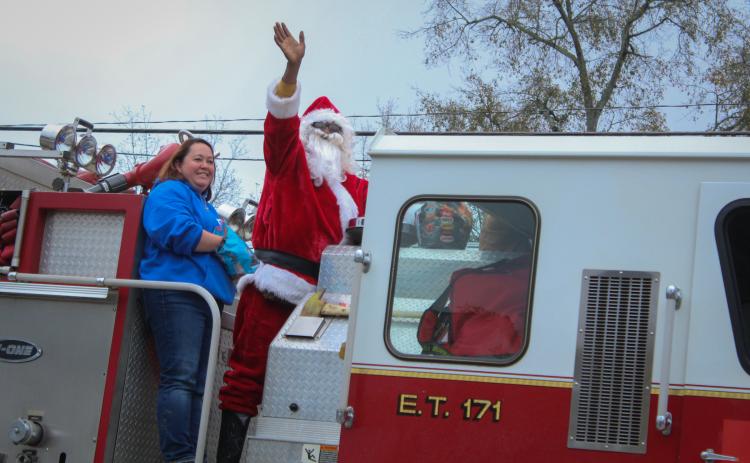 Santa waves to the crowd of people watching the War Room Show's community Christmas parade in Crawford, Georgia on Saturday, December 10, 2022. (Photo/ Basil Terhune)