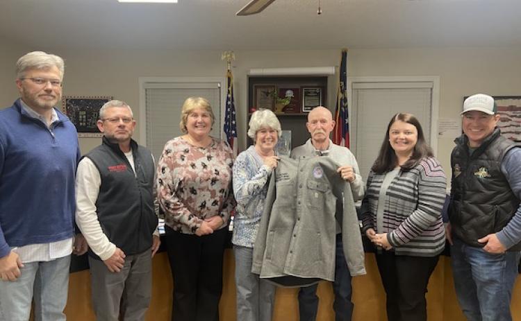 Longtime board member Dave Hawkins opens a present that was given to him during the BOE meeting on Tuesday, his last as a member of the board. (Emily Rose Hamby/The Oglethorpe Echo)