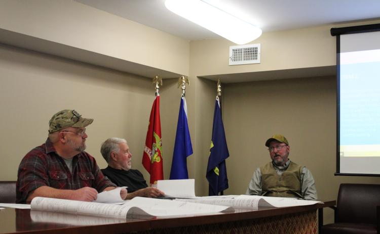 Oglethorpe County Zoning Board members Robert Drew (left)  and Jimmy Shealy discuss business with code compliance officer Jeff Sharp at the board meeting on Monday. The board approved a plan for a new coffee shop and a meat processing operation. (Photo/Sarah Donehoo)