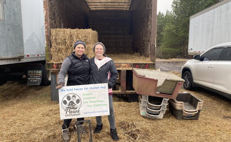 Heillyn Viquez (left) and Pam Fox, volunteers with Paws UnChained, handed out straw and dog houses at Oglethorpe County Feed and Hardware Supply earlier this month. (Erin Kenney/The Oglethorpe Echo)