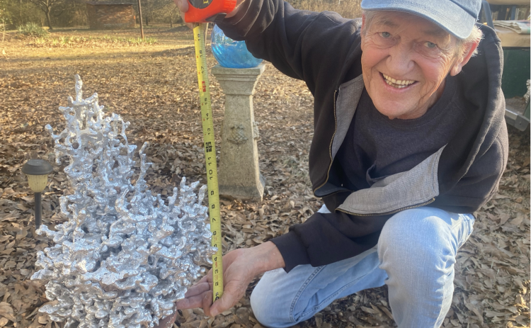 Alan Johnson displays one of the sculptures that’s created when he and longtime friend Benjamin Huish pour molten aluminum into anthills. (DINK NESMITH/THE OGLETHORPE ECHO)