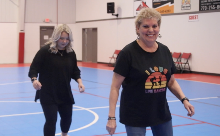 OLIVIA SHAPIRO/THE OGLETHORPE ECHO After teaching the steps to the line dance, One Step Forward, Two Steps Back, instructor Debbie Winsett puts music behind the moves.