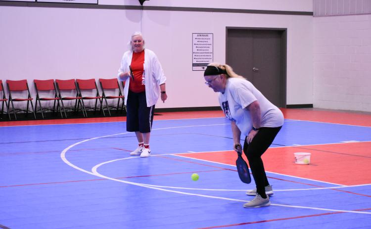 Crawford’s Karen Patman prepares to hit the ball as her partner Elaine McGarity, of Winterville, watches during a match at the Oglethorpe County Rec Center. They are two of a regular group of 16 players who play the fast-growing sport. (Photo/Molly Linder)