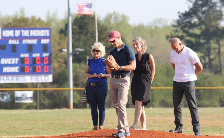Steve Harris, a son of former school superintendent Thomas Young (TY) Harris, prepares to throw out the first pitch before Oglethorpe County’s baseball game on Friday, March 24. The school system named the OCHS baseball field in honor of Harris, who died in February, 2022. All four of his children (from left): Paige Colquitt, Steve Harris, Suzanne Mingledorff and Thomas Harris IV attended the dedication. (Emily Dozier/ The Oglethorpe Echo)