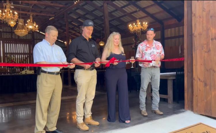 Oglethorpe County Commissioner Tracy Norman (from left), owners Blake and Shannon Bailey, and Crawford Mayor Seavy O’Neal prepare to officially open The Grove at Bailey Farms last Saturday. The new venue is on the site of the former Nix farm, which was owned by Aubrey Nix, who died in 1989. (SUBMITTED PHOTO)