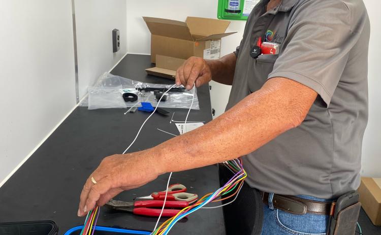 Arthur Burt works in a Kinetic by Windstream truck in Oglethorpe County earlier this month. Kinetic workers are installing optical fiber in Crawford and Lexington. (DINK NESMITH/THE OGLETHORPE ECHO)