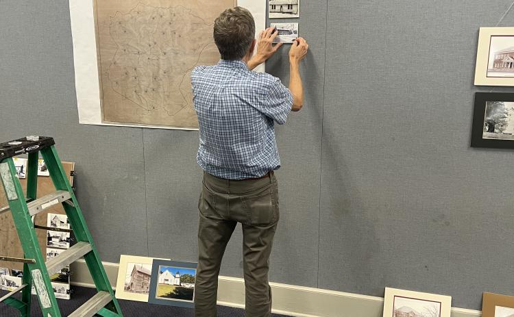 Tom Gresham assembles the “Back to School — 100 Years Ago” exhibit at the Oglethorpe County Library on Aug. 31. The exhibit, which was researched and is presented by the Digital Atlas of Historic Oglethorpe County, can be viewed throughout this month. (Photo/Jared Smith)