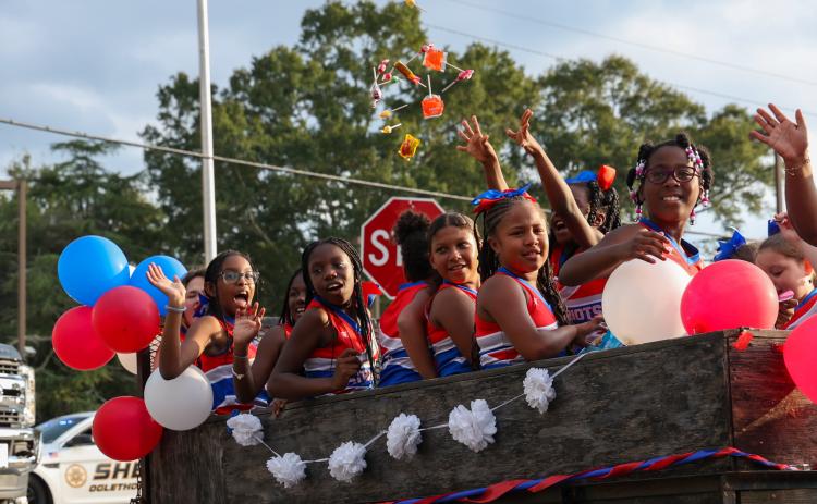 Members of an Oglethorpe County rec cheer team throw candy to spectators lining the parade route during the OCHS homecoming parade on Thursday, Sept. 21, 2023, in Crawford, Georgia. (Photo/Cassidy Hettesheimer)