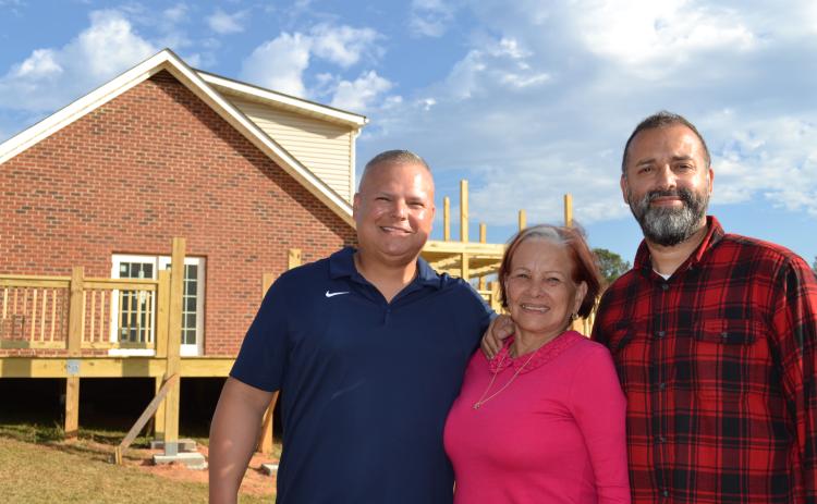 Josh Robayo (from left), Amy Delfin-Torres and Willie Torres stand in front of Town and Country Kafe, which will serve coffee and Spanish-inspired cuisine. The family plans to hold a grand opening early next month. (Grace Mains/The Oglethorpe Echo)