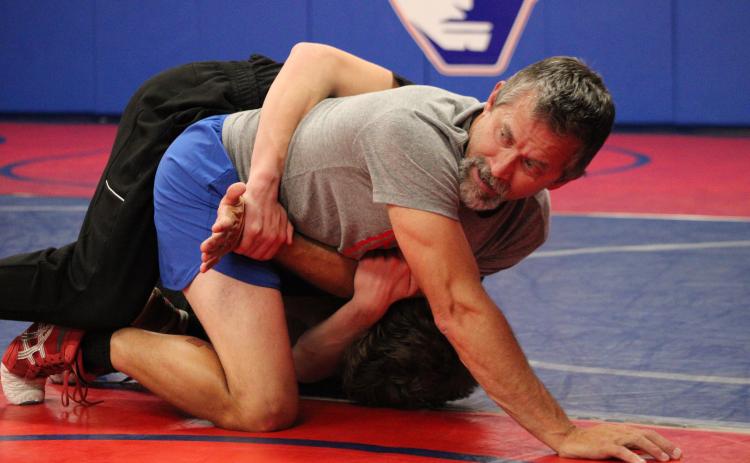 OCHS wrestling coach Tim Stoudenmire teaches his team a new move with help from senior Tanner Mask. Stoudenmire said there are more experienced wrestlers on this year’s team than last year. (LAUREN HILL/THE OGLETHORPE ECHO)