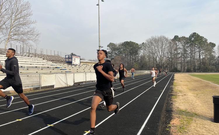 Oglethorpe County boys track coach Maurice Freeman runs with freshman Nicah Pass during a recent practice. Freeman is an OCHS grad who ran at Georgia before returning to Oglethorpe County. (Photo/HankTatum)
