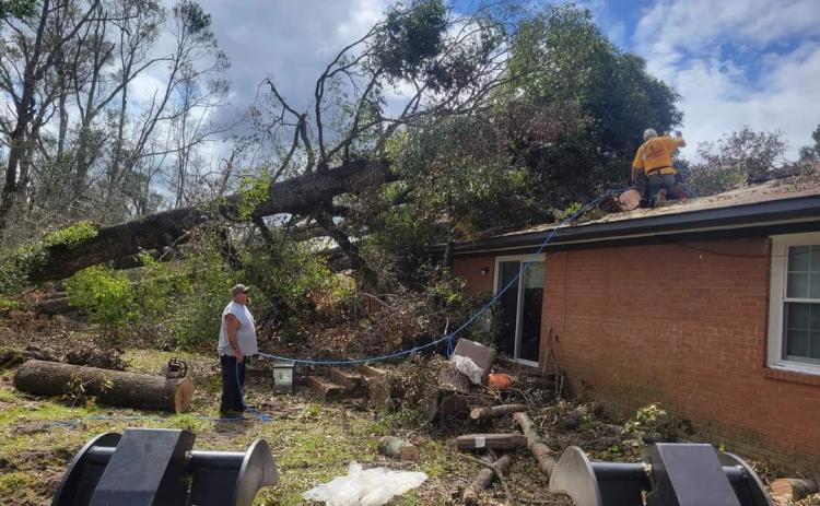 Members of the Georgia Baptist Disaster Relief team clear a tree off a roof in Vidalia, GA. Following the Sept. 24 landfall of Hurricane Helene, many yards are in disrepair and covered in debris. (Photo / Howard Sanders)