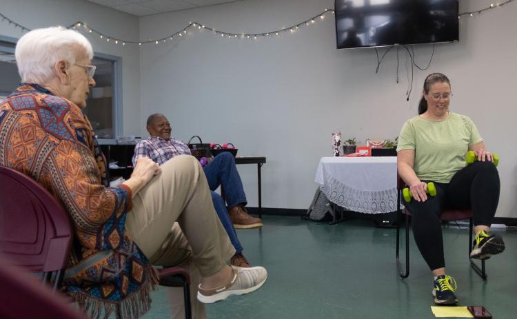 From left: Ginny Crafton and Charles Huff lift their legs in an exercise routine led by Sarah Baker at the Oglethorpe County Senior Center on Feb. 6, 2025. (Photo / Lux Corrona)