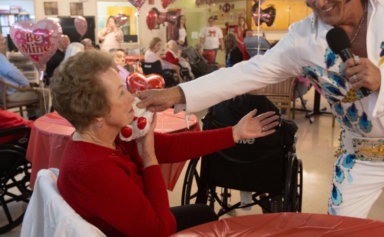 Geneva Stamey shares an exchange with Elvis tribute artist E.J. Boyer as he hands her a teddy bear at Quiet Oaks Nursing Home in Crawford, Ga on Feb. 14, 2025. Stamey is Oglethorpe County's former Clerk of Court, and came to visit Quiet Oaks during their annual Valentine's day event in order see Elvis. (Photo / Lux Corrona)