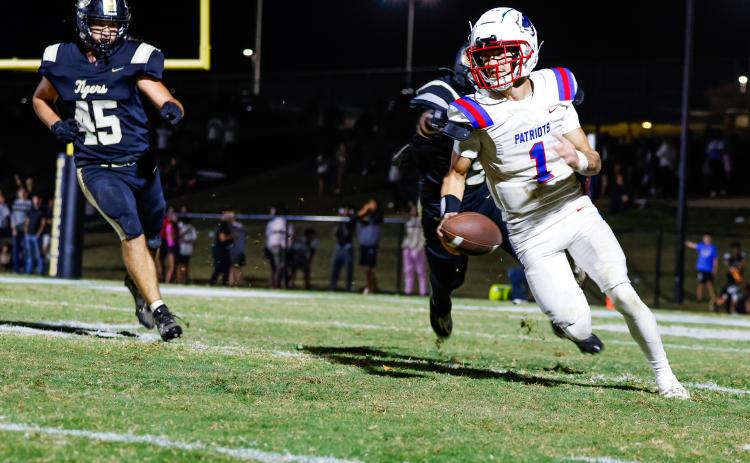 DREW BEARDEN/THE OGLETHORPE ECHO Oglethorpe County’s Caden Hartrum scrambles away from Commerce players on Friday. Hartrum threw a touchdown pass in the 24-14 victory.
