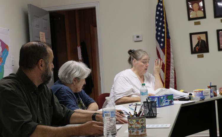 Crawford City Clerk Amy Wall-Lance (right) discusses the meeting agenda to the city council on Oct. 14. Willie Torres (left), who recently replaced Sandra Sheridan as a council member, and Brenda Butler (middle) listen to Wall-Lance. (Ansley Gavlak/The Oglethorpe Echo)